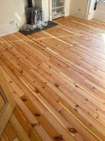 Lounge and hall replacement with 95mm machined reclaimed redwood knotty pine floorboards.